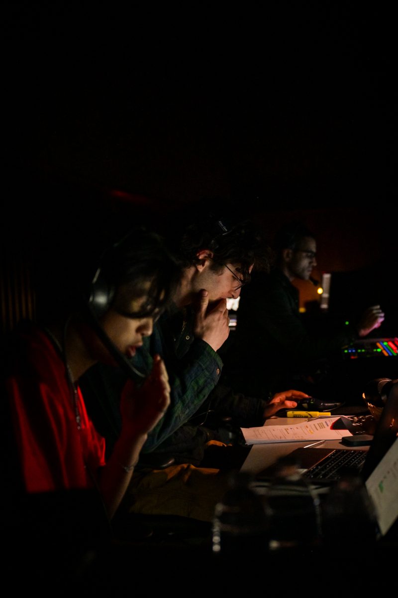 Members of Logan Center’s technical crew coordinate lights and sound during the show.