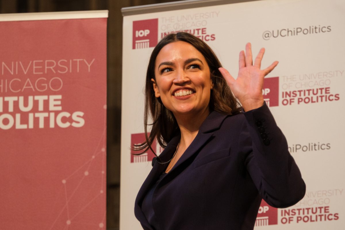 Representative Alexandria Ocasio-Cortez (D-N.Y.) waves to a crowd of observers in Rockefeller Chapel. 